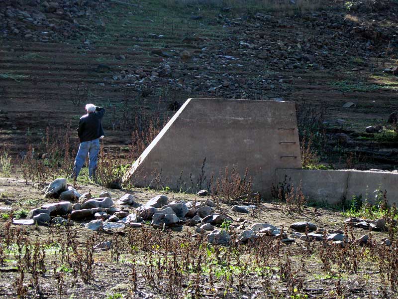 John looks up-slope near concrete waterworks structure