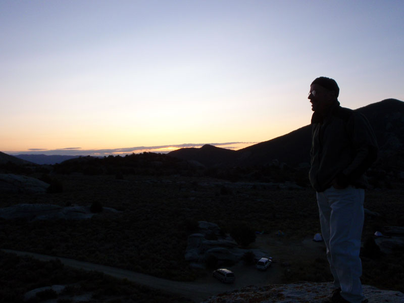 Doug on rock, camp below